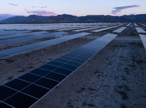 Solar farm with clouds over mountains